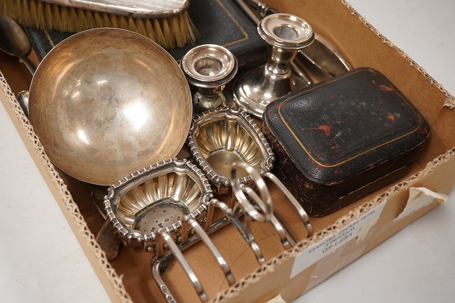 A small group of assorted silver and white metal items including a cased matched pair of Victorian silver pepperettes, an Edwardian silver five bar toastrack, a pair of late Victorian silver salts by William Hutton & Son